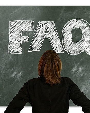 Frau vor Schultafel mit FAQ Aufschrift Bild: Frau vor Schultafel mit FAQ Aufschrift
