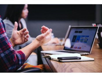 Mann gestikuliert bei einem Meeting